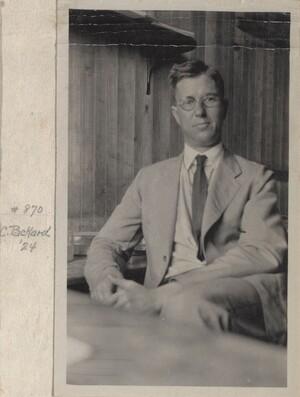Packard sitting at his desk, facing the camera